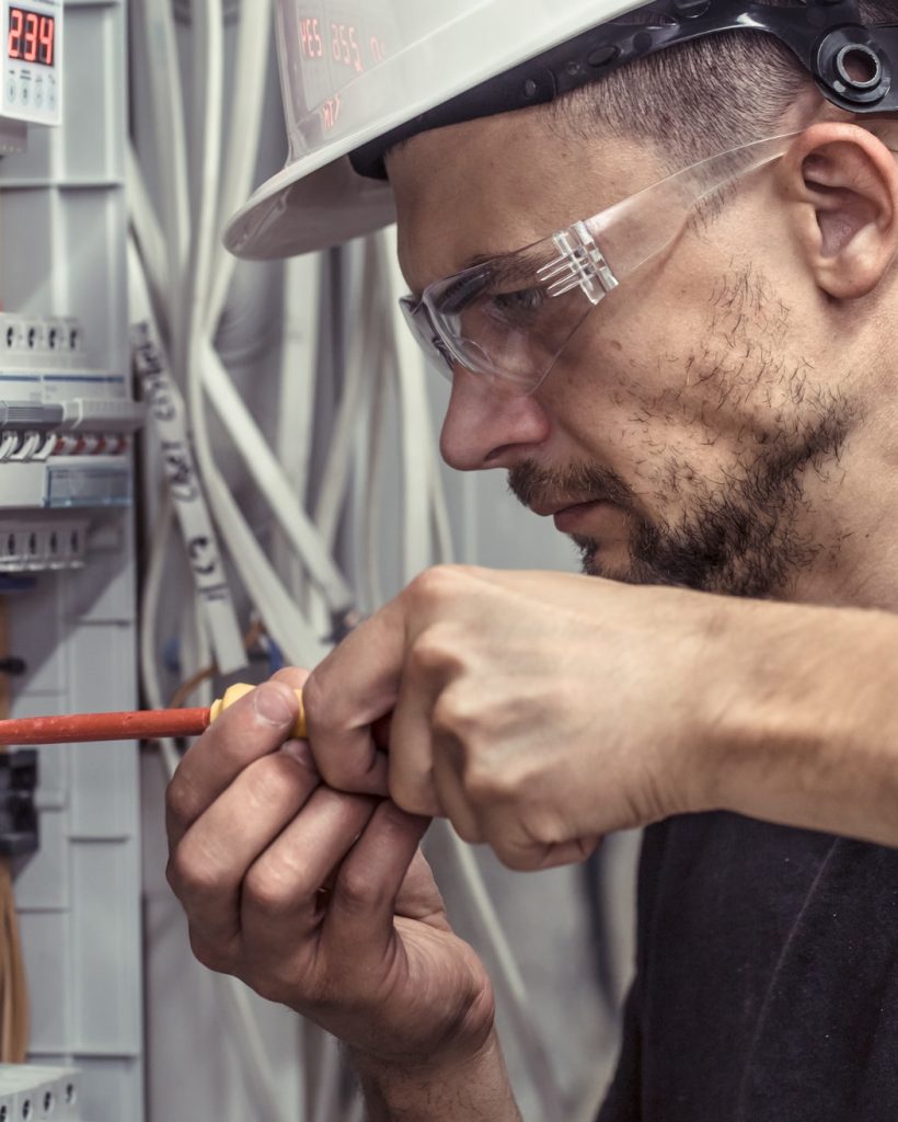 a male electrician works in a switchboard with an electrical connecting cable.jpg